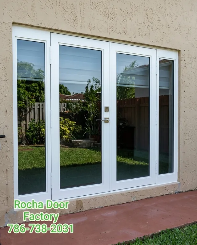 White impact French doors with sidelites opening to a backyard