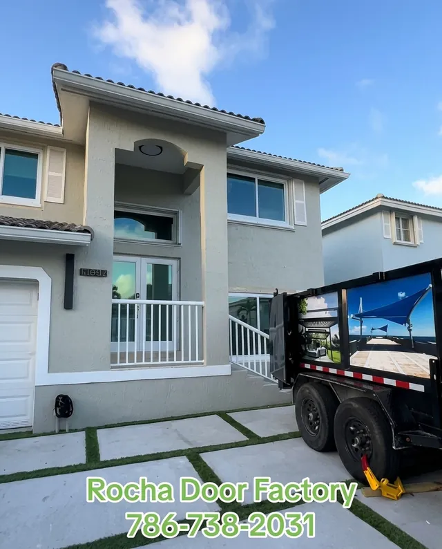 Two-story home with new impact doors and windows and the Rocha Door Factory trailer